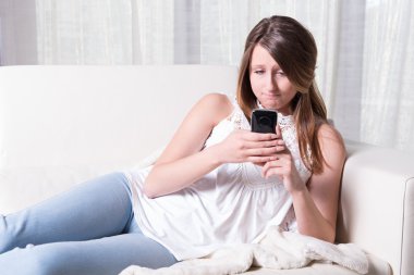 attractive young girl reading a bad message on smartphone