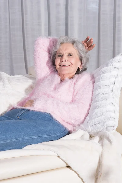 Attivo femminile anziano rilassante sul divano — Foto Stock
