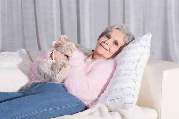 Active female senior relaxing on couch — Zdjęcie stockowe