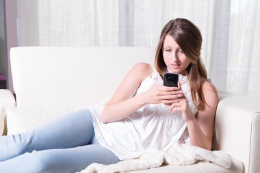 attractive young girl reading a scary message on smartphone