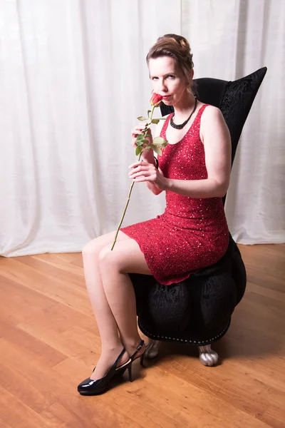 Femeie atractivă în rochie roșie cu trandafir — Fotografie, imagine de stoc
