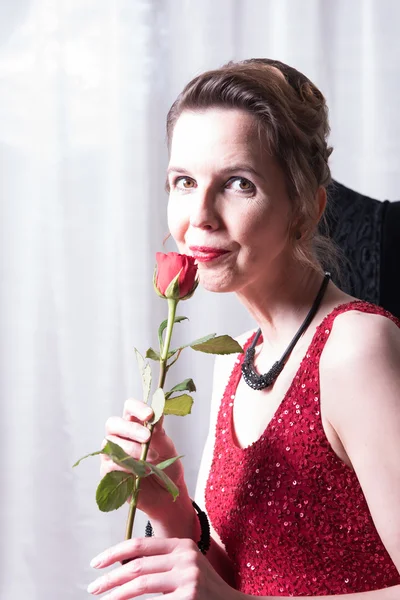 Femeie atractivă în rochie roșie cu trandafir — Fotografie, imagine de stoc