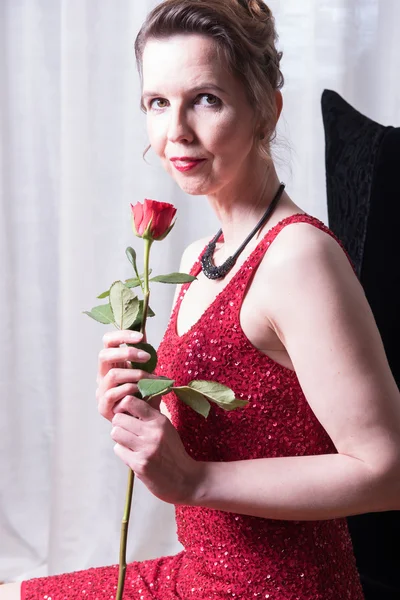 Attractive woman in red dress with rose — Stock Photo, Image