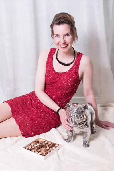 Woman in red dress with dog on blanket — Stock Photo, Image