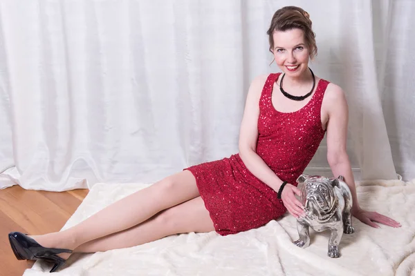 Woman in red dress with dog on blanket — Stock Photo, Image