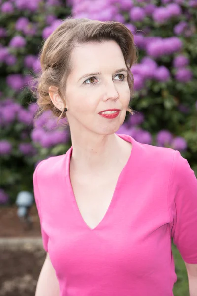 Attractive woman in purple in the garden — Stock Photo, Image