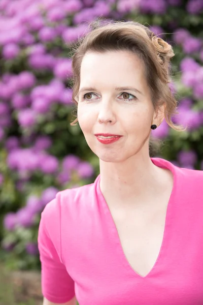 Attractive woman in purple in the garden — Stock Photo, Image