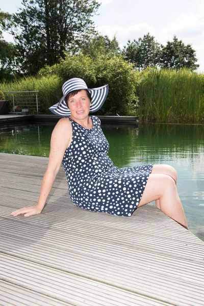 Mulher atraente siiting com pernas na piscina — Fotografia de Stock