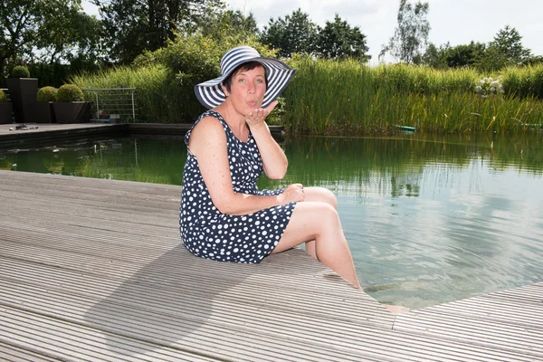Attraktiv kvinna siiting med ben i poolen — Stockfoto