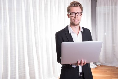 Portre genç iş adamı elbiseli laptop ile çalışma