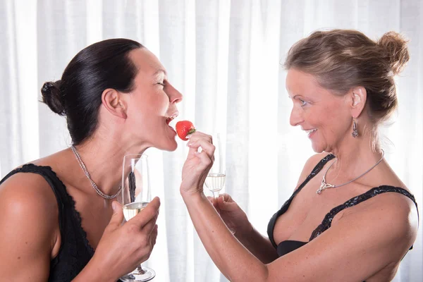 Due donne attraenti - una sta nutrendo l'altra con fragola — Foto Stock
