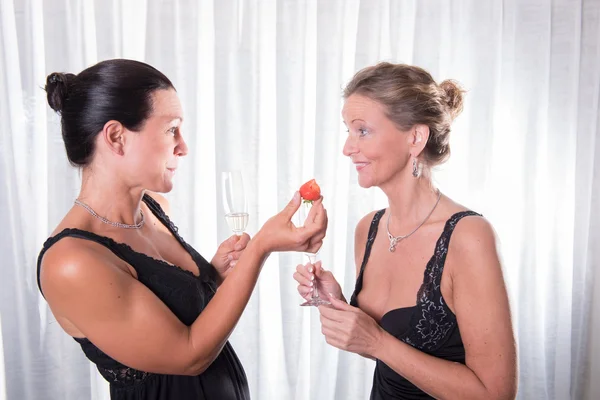 Due donne attraenti - una sta offrendo fragola alla sua amica — Foto Stock