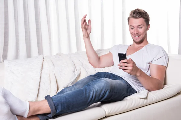 Young man likes message on smartphone — Stock Photo, Image