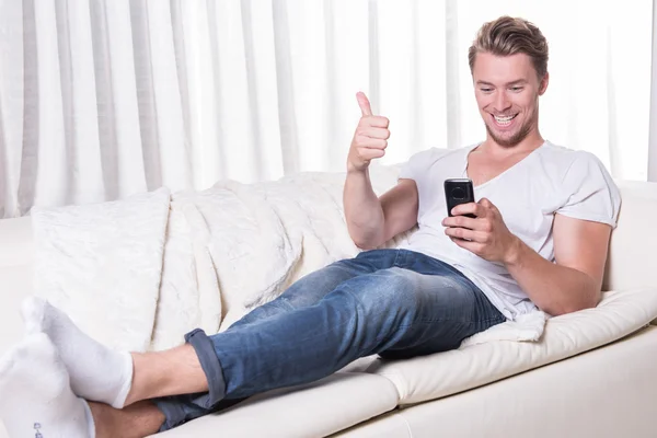 Young man likes message on smartphone — Stock Photo, Image