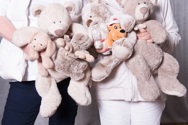 Female helpers offer toys to refugee children — Stock Photo, Image