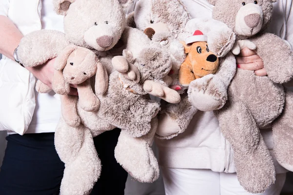 Female helpers offer toys to refugee children — Stock Photo, Image