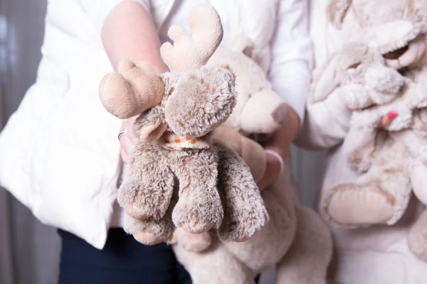 Female helpers offer toys to refugee children — Stock Photo, Image