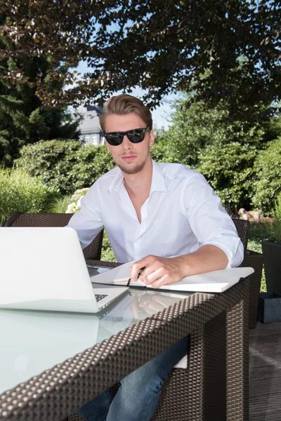 Student is working with laptop and book in the garden — Stock Photo, Image