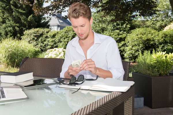 genç iş adamı dolar bahçede sayıyor