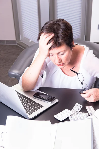 Attraktiv kvinna i hennes hem kontor överarbetad med medicin — Stockfoto