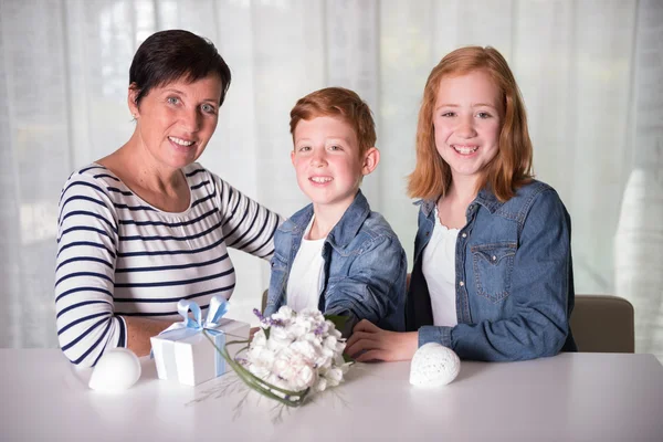 Gelukkige familie vieren verjaardag met presenteert en bloemen — Stockfoto