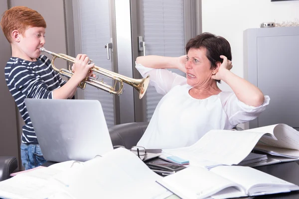 Mutter arbeitet im Homeoffice, Sohn stört beim Spielen — Stockfoto