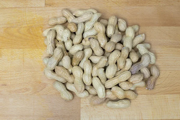 Peanuts lying on a wooden bckground — Stock Photo, Image