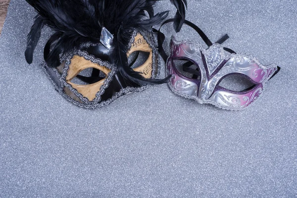 Duas máscaras de carnaval com penas sobre glitter — Fotografia de Stock