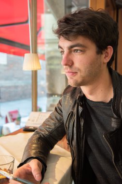 cep telefonunuzla kafede oturan ve dışında arayan genç adam