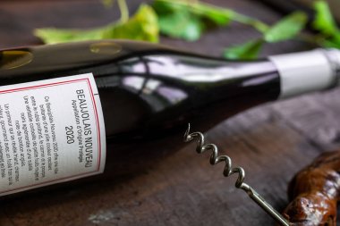 LE MANS, FRANCE - 19 Kasım 2020: Bir şişe Fransız şarabı Beaujolais Nouveau 2020, Georges Duboeuf, ahşap arka planda