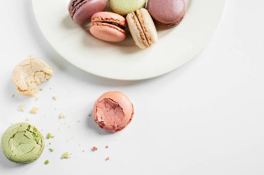 Beyaz bir masa üzerinde farklı renklerde geleneksel fransız kurabiyeleri, kopya alanı ile üst görünüm