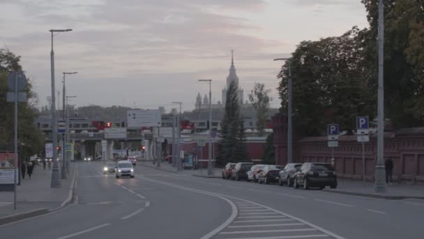 ルズネツキー通過とモスクワ中央円線 車の交通だ モスクワ国立大学を背景に — ストック動画