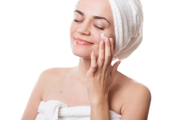 Chica en toallas aplicando crema en su cara después del baño —  Fotos de Stock