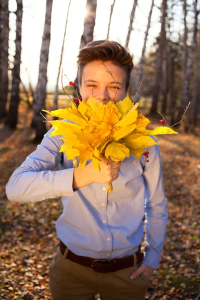 Guy holding bouquet of autumn leaves — Stock Photo, Image