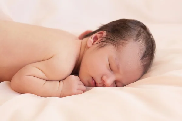 Новорожденный на бежевом фоне — стоковое фото