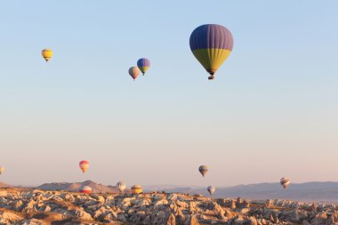 Gündoğumu zaman gökyüzünde uçan çok renkli balonlar