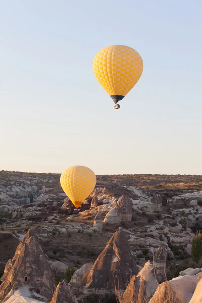 Balões amarelos voando no céu, hora do nascer do sol — Fotografia de Stock