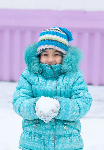 Happy kid girl child outdoors in winter playing holding snow — Stock Photo, Image