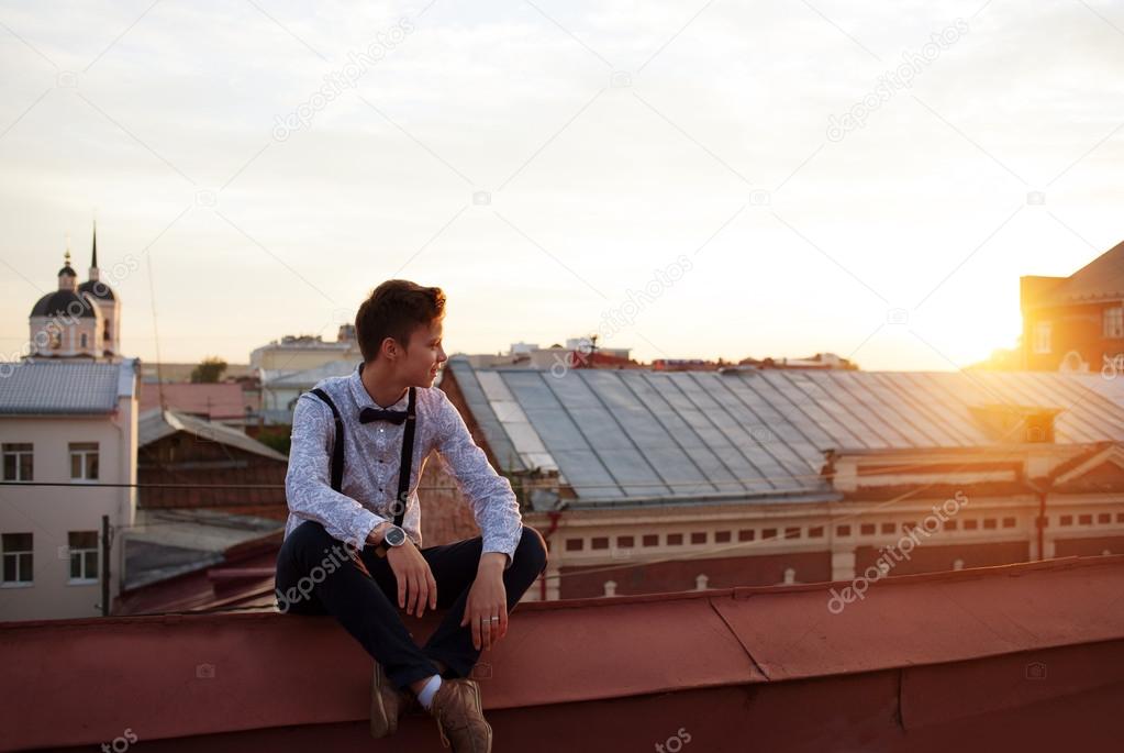 Happy hipster girl on the edge of the roof
