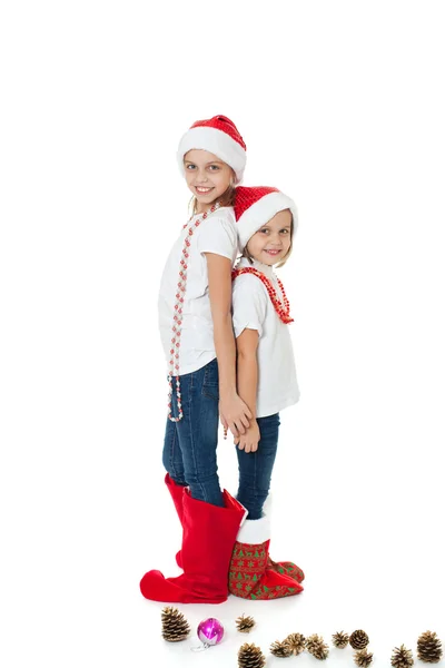 Happy sisters in santa's hats and gift socks — Stock Photo, Image