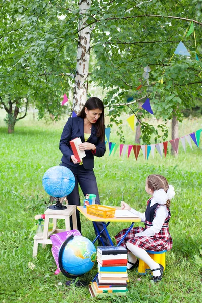 Beautiful asian woman teacher talking reading book to shoolgirl — Stock Photo, Image