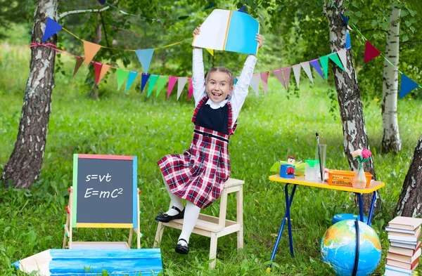 Skolflicka barn kid flicka bo på stol håller boken notebook ab — Stockfoto