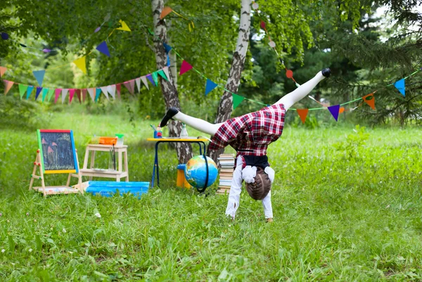 Lycklig skolflicka barn kid flicka hoppande tumlande roterande handspr — Stockfoto