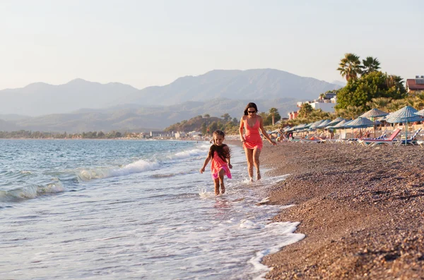어머니와 그녀의 어린 딸 고 해변에서 실행 — 스톡 사진