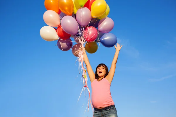 Красивая счастливая молодая беременная девушка на улице с воздушными шарами — стоковое фото