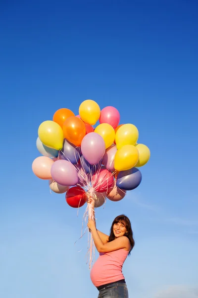 Schöne glückliche junge schwangere Frau Mädchen im Freien mit Luftballons — Stockfoto