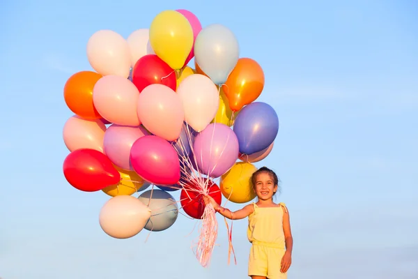 Gelukkig klein meisje kind kind met ballonnen buitenshuis op sky backgr — Stockfoto