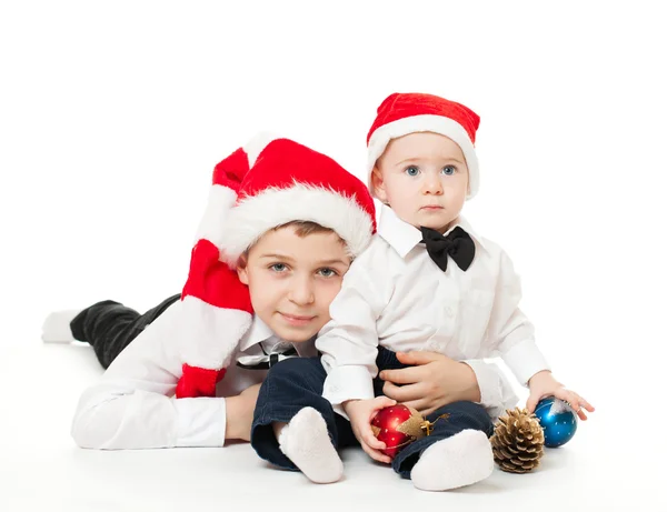 Boys brothers in santa's hats hugging — Stock Photo, Image