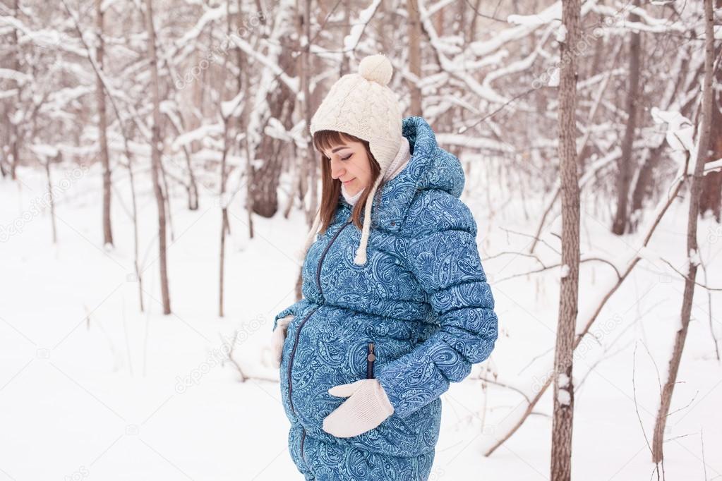 Pregnant woman in winter forest