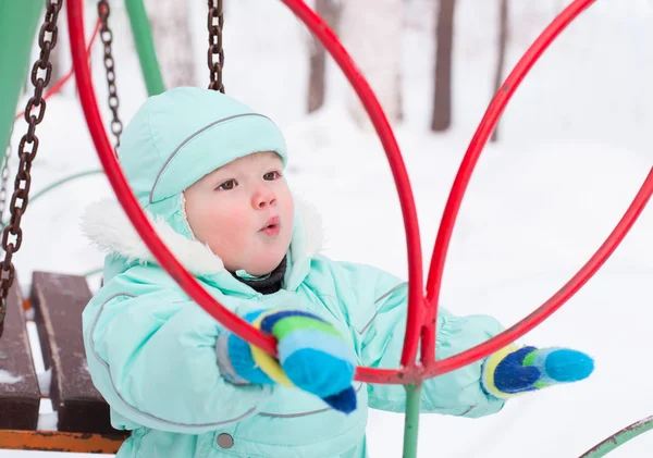 Bonito menino brincando no parque no inverno — Fotografia de Stock